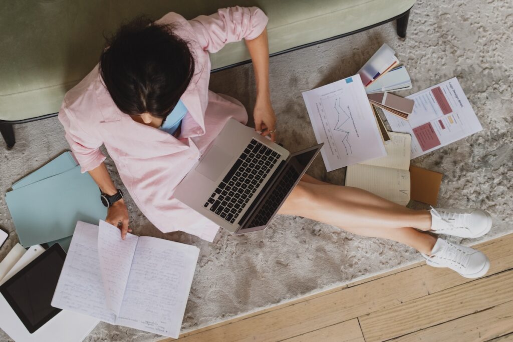 woman with her laptop and lots of papers brainstorming business growth strategies