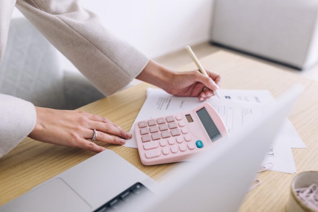 woman at her desk calculating and writing down goals for her small business