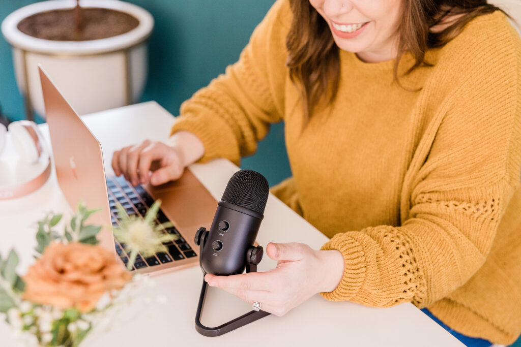 woman sitting at desk with laptop and microphone