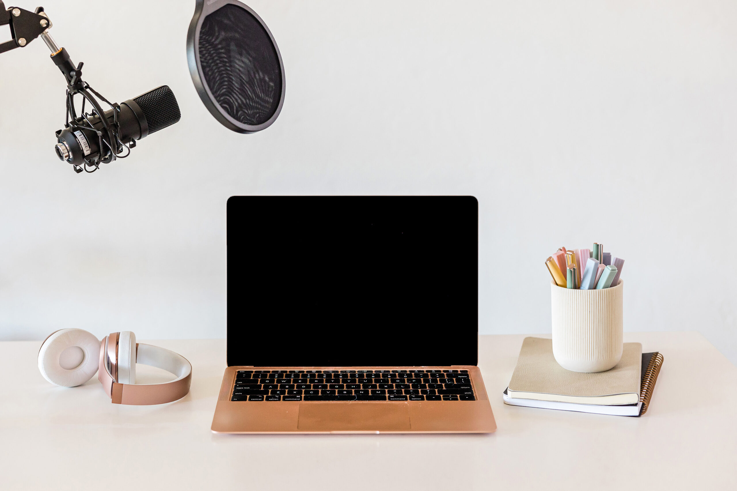 laptop on desk with microphone and headphones