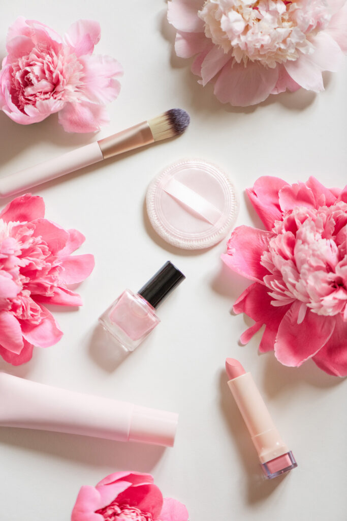 flat lay with pink flowers and makeup